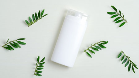 Organic shampoo bottle or hair lotion branding mockup and green leaves. Natural hair care product...