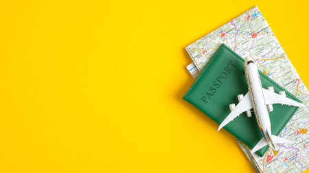 Flat lay airplane model, passport and map on yellow background. Top view with copy space. Travel...