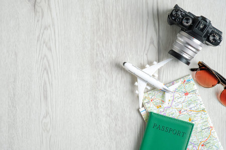 Traveler accessories on wooden table. Top view vintage camera, airplane model, map, passport...