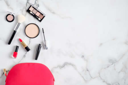 Beautician kit bag top view. Flat lay makeup pouch with beauty products and cosmetics on marble background with copy space. Beauty and fashion conceptの写真素材
