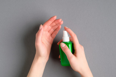 Woman applying antibacterial antiseptic spray for hand. Coronavirus Disease (Covid-19) prevention...