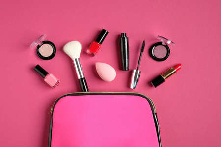 Make up bag with cosmetic products on pink background. Flat lay, top view. Beauty and fashion concept.の写真素材