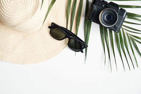 Traveler accessories with tropical palm leaf branches on white background. Travel vacation concept....