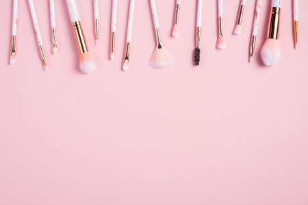Frame of makeup brushes on pink background. Flat lay, top view. Make up shop banner mockup.