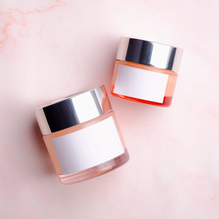 Cosmetic cream jars on pink background. Beauty product containers with white labels, packaging...
