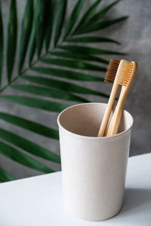 Eco-friendly bamboo toothbrushes in glass. Natural wooden oral hygiene accessories. Zero waste, plastic free, sustainable lifestyle conceptの写真素材