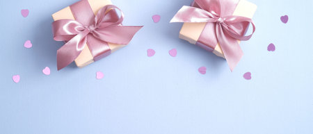 Valentines Day background with gift boxes decorated pink ribbon bow and heart shaped confetti....