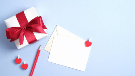 Valentine gift and love letter on pastel blue background. Happy Valentines Day flat lay composition.