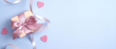 Valentines Day background with gift box with pink ribbon bow and hearts. Flat lay, top view. Banner...