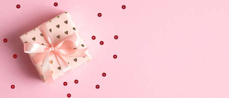 Gift box on pink background with confetti. Valentines Day gift or birthday present concept. Flat lay, top view. Valentines Day banner templateの写真素材