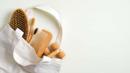 Zero waste bathroom accessories in cotton bag. Bath peeling brush, wooden hair comb, massage tool, bamboo toothbrushes. Eco-friendly bath products, beauty and SPA treatment conceptの写真素材