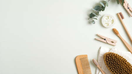 Zero waste bathroom accessories on green table. Top view bath peeling brush, wooden hair comb, bamboo toothbrushes, luffa sponge, towel. Eco-friendly bath products, beauty and SPA treatment conceptの写真素材
