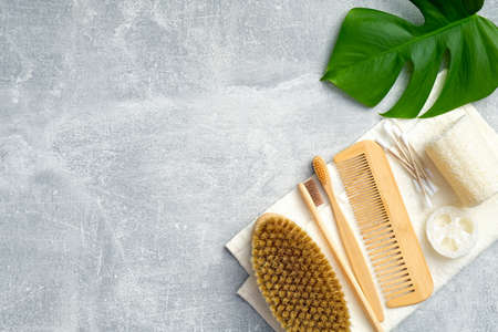 Bath accessories and natural SPA beauty products with green leaf on stone background. Personal hygiene and body treatment concept. Flat lay, top viewの写真素材