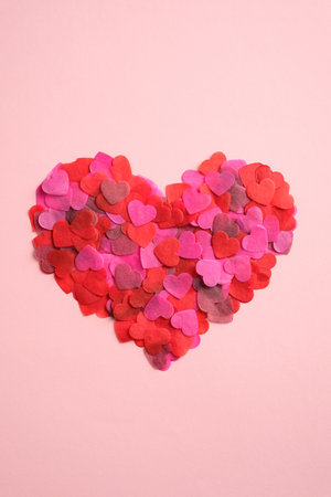 Heart shape made of hearts confetti on pink table. Top view, flat lay. Minimal style. Happy Valentines Day conceptの写真素材