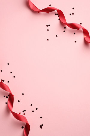 Happy Valentine's Day concept. Vertical banner design with red ribbons and heart shaped confetti on pink background. Holiday brochure design, greeting card, gift voucher template. Minimal style.の写真素材