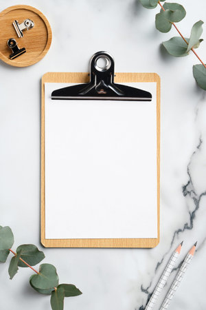 Home office desk with clipboard mockup, office supplies and eucalyptus leaves on marble background.の写真素材