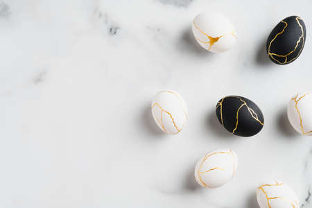Elegant Easter eggs decorated with gold on marble background. Flat lay, top view. Luxury Easter banner template.の写真素材