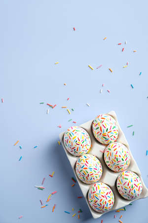 Colorful Easter eggs on pastel blue background. Creative design, flat lay, top view.の写真素材