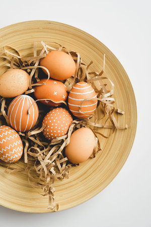 Plate with nordic Easter eggs on white background. Flat lay, top view. Happy Easter concept.