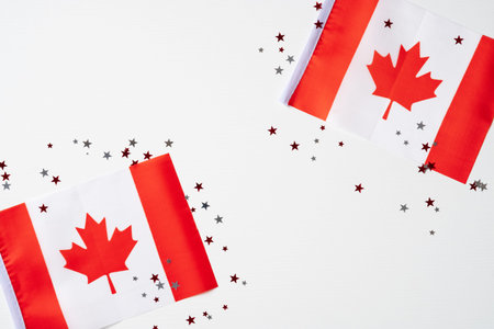 Happy Canada Day poster. 1st of July. Canadian flags with maple leaves and confetti on white background.の写真素材