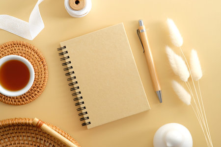 Craft paper notepad and pen with dried flowers on beige table. Elegant feminine workspace, home...