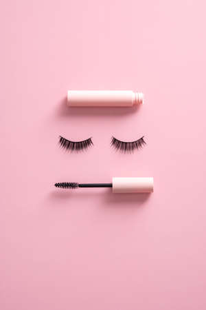 Creative flatlay composition with mascara and false eyelashes on pink background. Makeup cosmetics set.の写真素材