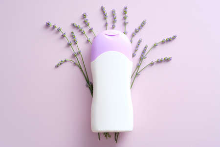 Herbal shampoo bottle mockup with lavender on purple background. Flat lay, top view.の写真素材
