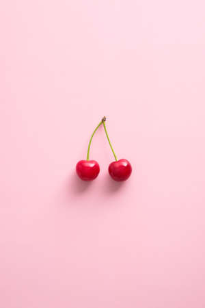 Double cherry berries on pink background. Flat lay, top view.の写真素材