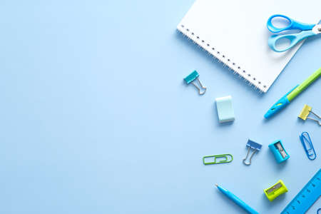 Flat lay school stationery on blue desk table. Top view, overhead. Back to school concept.の写真素材