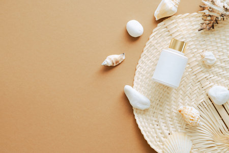 Sunscreen cream lotion bottle and seashells on sandy color background. Flat lay, top view, overhead.の写真素材