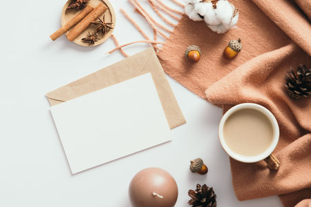 Autumn composition. Feminine desk table with scarf, coffee cup, blank paper card mockup with...