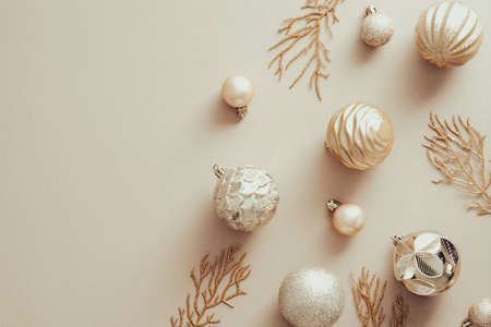 Christmas golden balls decorations on beige background. Xmas banner mockup with copy space. Flat lay, top view.の写真素材