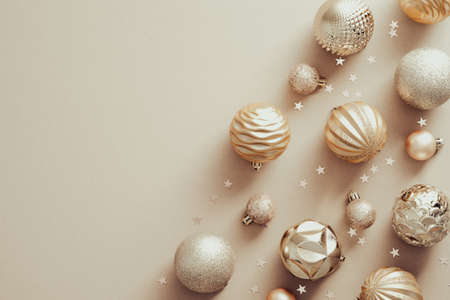 Christmas background with elegant balls decorations and confetti on beige. Xmas banner mockup, greeting card design. Flat lay, top view, copy space.の写真素材
