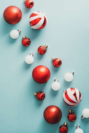 Vintage Christmas flat lay composition with red and white balls on green background. Retro style Xmas decorations top view.の写真素材