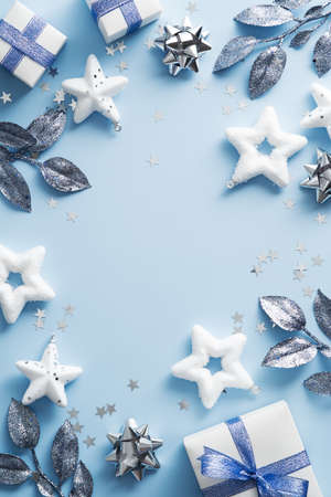 Happy Christmas day background. Elegant Xmas decorations, stars, branches on blue table. New Year vertical banner design, Christmas poster mockup. Flat lay, top view.の写真素材
