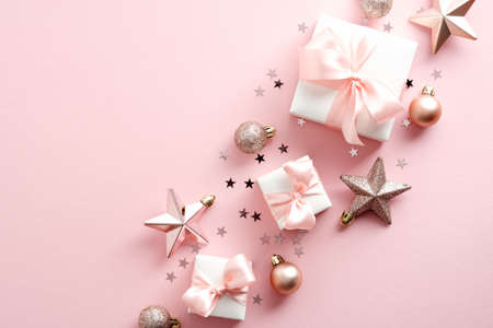 Elegant Christmas composition with gift boxes, decorations, stars, confetti on pastel pink background. Flat lay, top view, overhead.の写真素材
