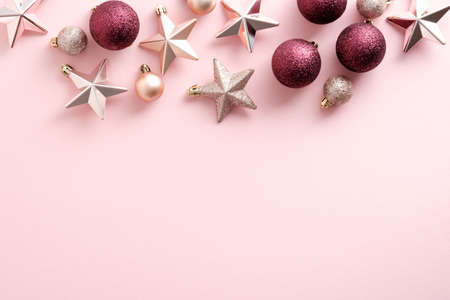 Pink Christmas background with glittering stars and baubles. Flat lay, top view. New Year banner design with elegant decorations.の写真素材