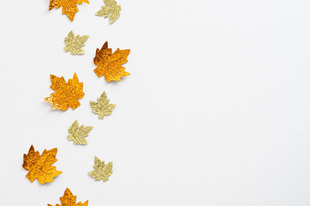 Golden maple leaves decorations on white background. Autumn, fall concept. Flat lay, top view, overheadの写真素材