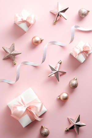 Elegant Christmas decorations, gift box, ribbon on pastel pink background. Christmas poster. Flat lay, top view.の写真素材