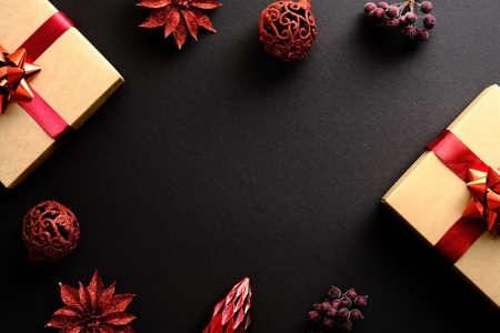 Christmas frame with gifts, red decorations, balls over black background. Flat lay, top view, copy space. Christmas banner mockup, New year postcard templateの写真素材