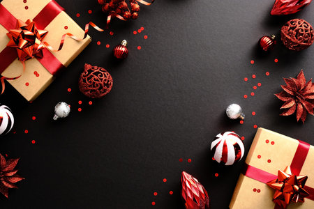 Red Christmas decorations and gifts on dark black background. Christmas greeting card mockup, Xmas...