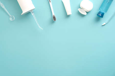 Dental professional oral irrigator, toothpaste, toothbrush, liquid, flosser on blue background. Flat lay, top view. overhead. Dental clinic banner design.の写真素材