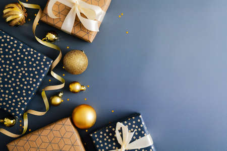 Christmas blue background with gift boxes, gold baubles, ribbon. Flat lay, top view, copy space. Merry Christmas and Happy New Year greeting card design.の写真素材