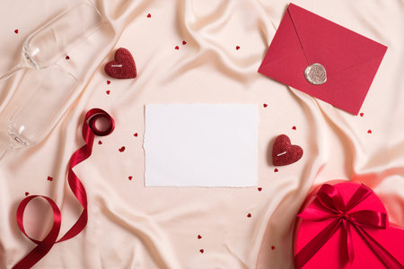 Blank paper card mockup, red envelope, ribbon, heart shaped box, hearts on silk. Happy Valentines day, anniversary, wedding concept.の写真素材