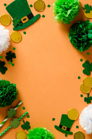 St Patricks Day vertical banner design with leprechaun hats, gold coins, confetti, decorations on orange background. Happy Saint Patricks Day frame border.の写真素材