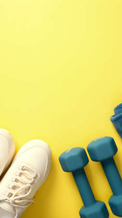 Feminine sport workout equipment on yellow background. Active lifestyle concept. Sport blog vertical banner design.の写真素材