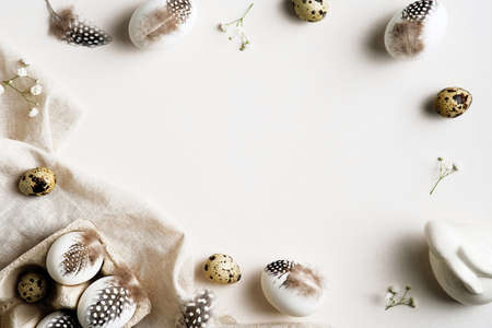 Easter flat lay composition. Easter eggs with feathers on white background. Happy Easter card template.の写真素材