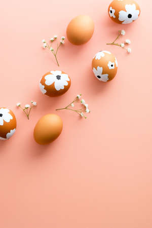 Easter eggs with gypsophila flowers on color background. Flat lay, top view, vertical.の写真素材
