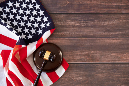 Judge gavel and American flag on wooden table. Flat lay, top view, copy space.