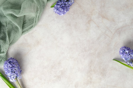 Spring flat lay with purple hyacinth flowers and green fabric on a stone textured backgroundの写真素材